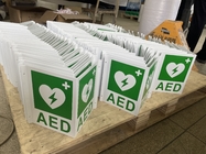 白い壁の台紙AEDの壁の印の緑のプラスチック除細動器AEDピース サイン注文アルミニウムAEDの印